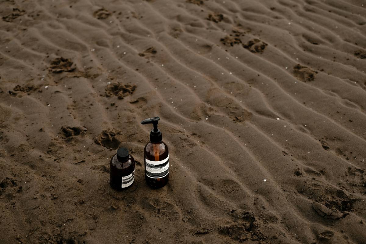 Woman applying sunscreen for the body evenly on her legs at the beach