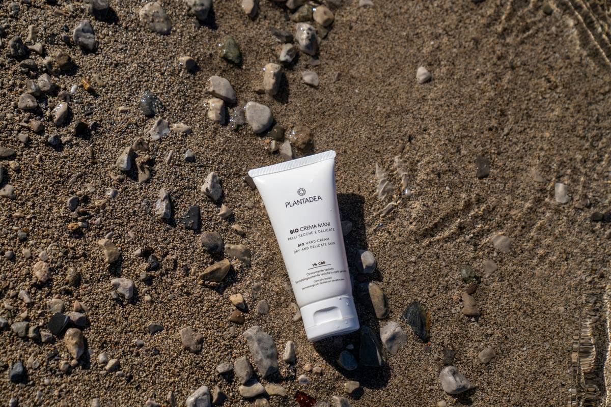 woman applying skincare essential sunscreen skin that is evenly on arms outdoors
